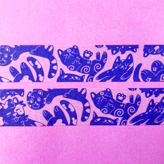 Two rolls of purple washi tape with blue cat designs on a pink background